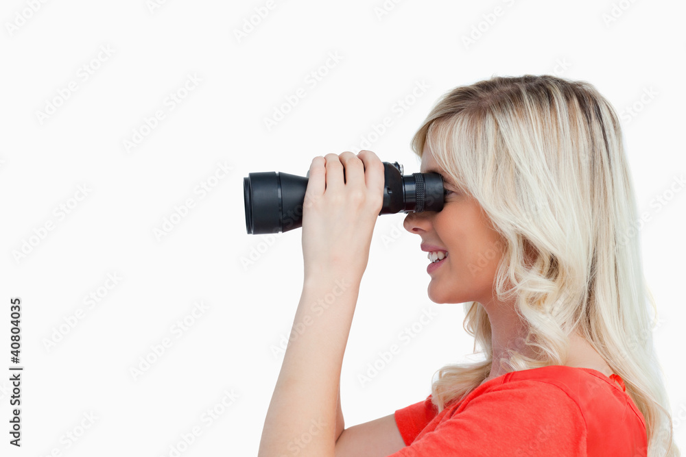 Side view of an attractive woman looking through binoculars Side view of an attractive woman looking through binoculars