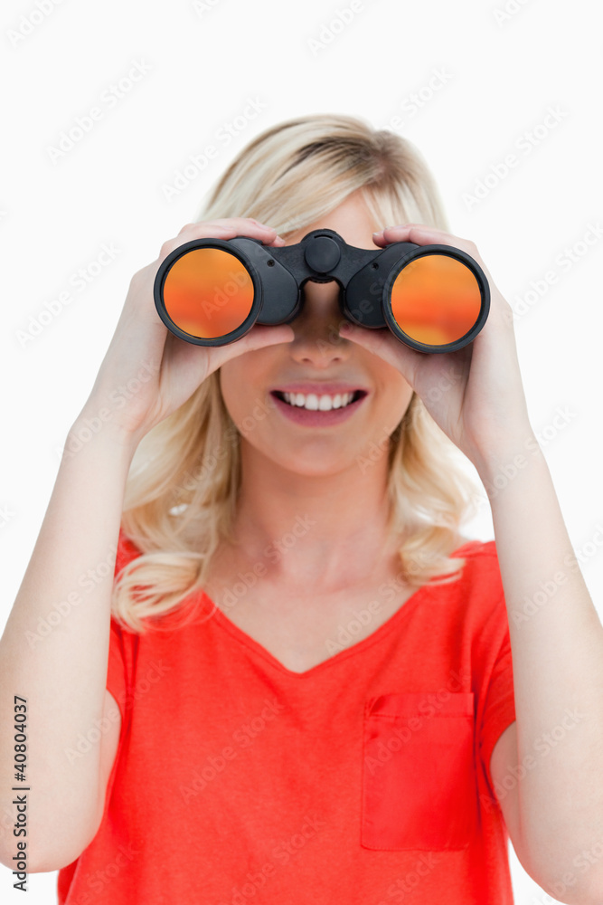 Smiling woman looking through binoculars Smiling woman looking through binoculars