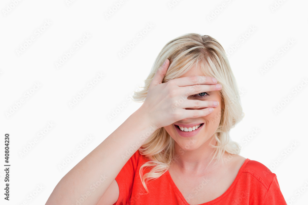 Young woman trying to see through her fingers placed in front of Young woman trying to see through her fingers placed in front of