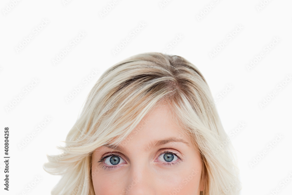 Upper part of a blonde woman's face looking straight at the came