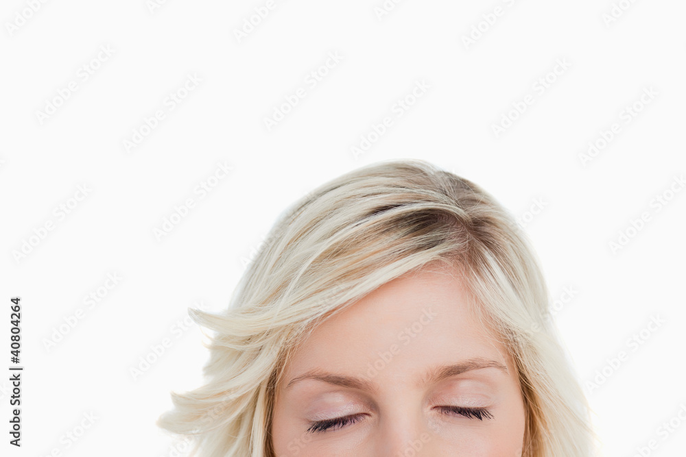 Woman closing her eyes while hiding the lower part of her face Woman closing her eyes while hiding the lower part of her face