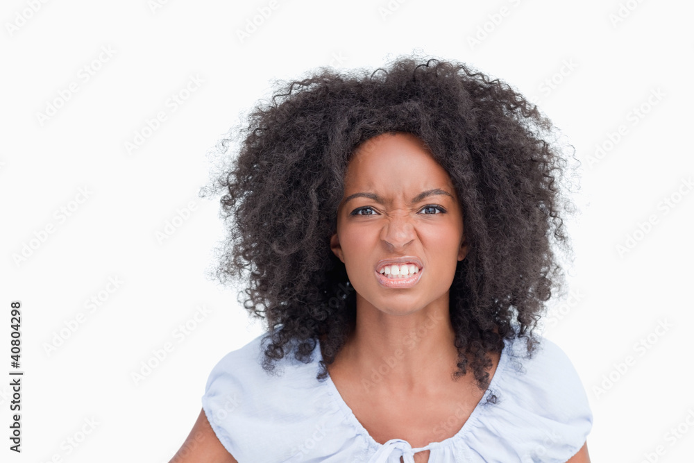 © WavebreakmediaMicro - Young woman with curly hairstyle showing teeth to indicate her a