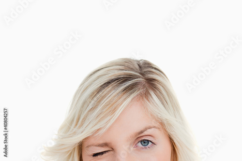 Obraz na plátne Upper part of the face of a fair-haired woman blinking an eye