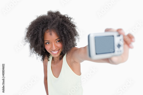 Smiling young woman photographing herself