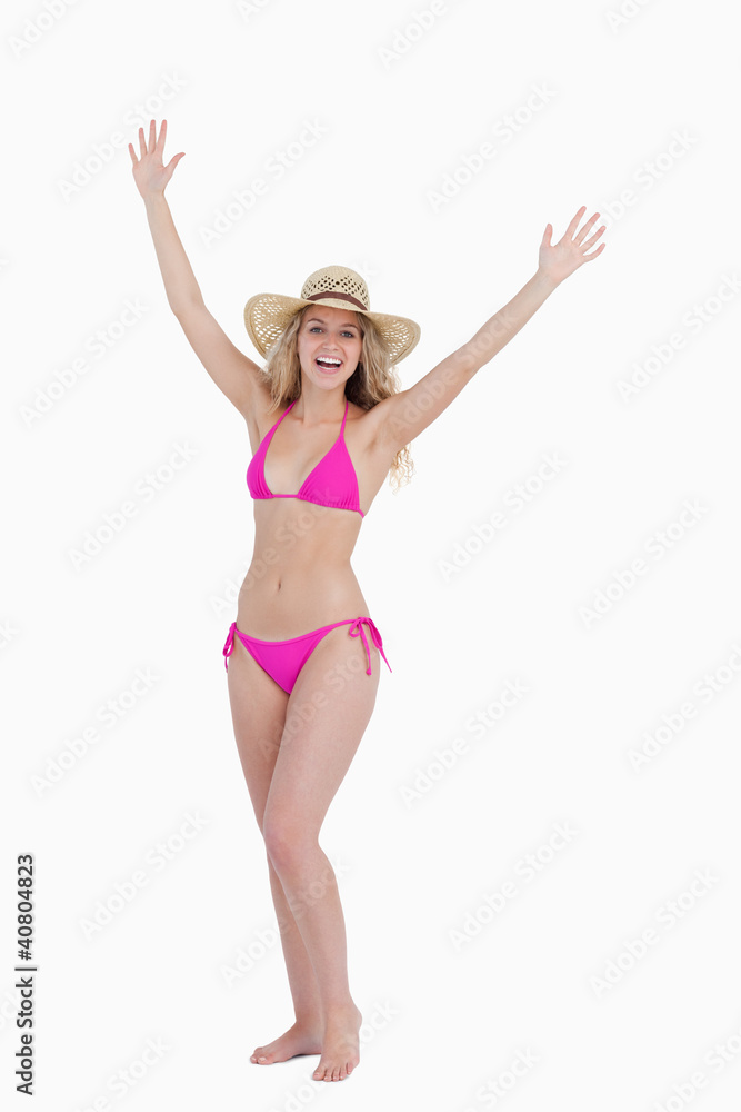 Blonde teenager raising her arms while standing upright