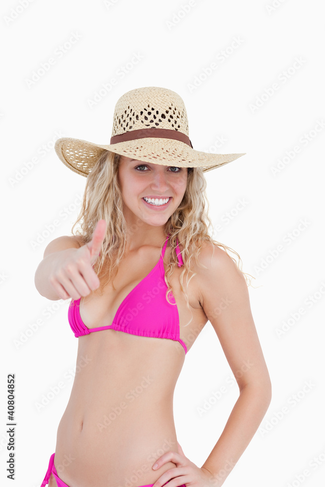 Thin teenager in beachwear showing her thumbs up Thin teenager in beachwear showing her thumbs up
