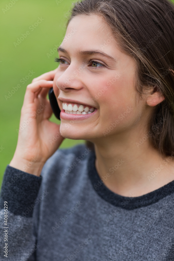 Young smiling girl calling with her cellphone while standing up Young smiling girl calling with her cellphone while standing up