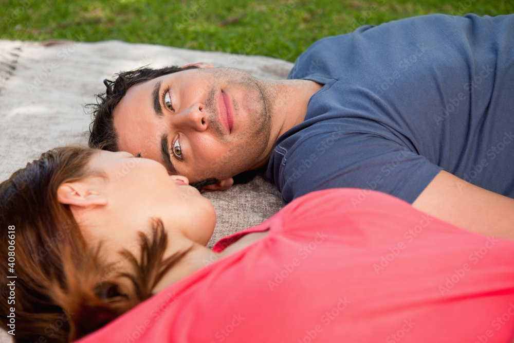 Man looking into his friends eyes while lying on a quilt Man looking into his friends eyes while lying on a quilt