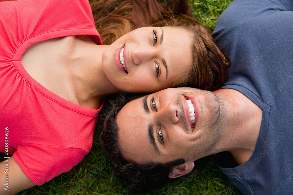 Two friends smiling while lying head to shoulder Two friends smiling while lying head to shoulder