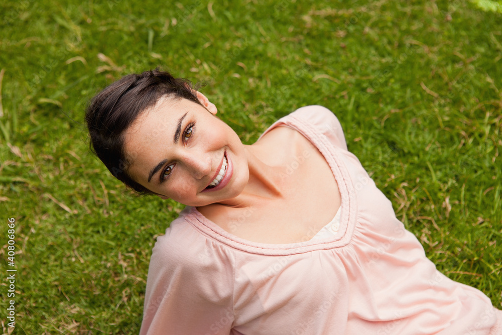 Smiling woman tilting her head while lying down Smiling woman tilting her head while lying down