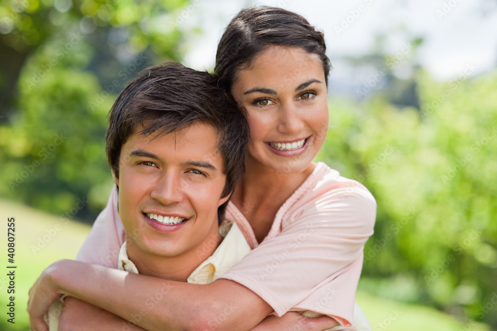 Woman smiling with her friend who is carrying her Woman smiling with her friend who is carrying her