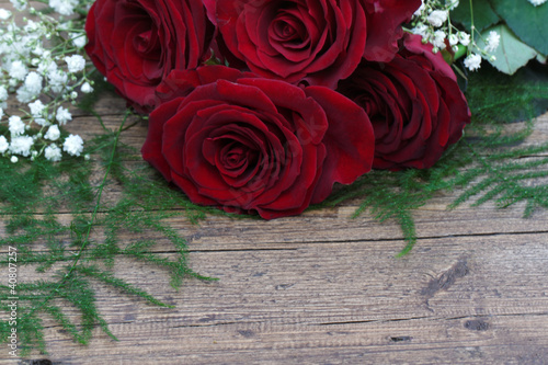 Rote Rosen auf braunem Holzuntergrund