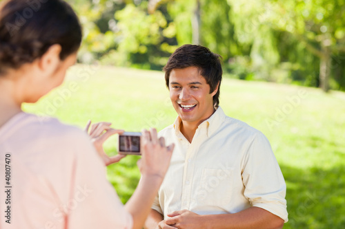 Woman takes a photo of her friend while hes laughing