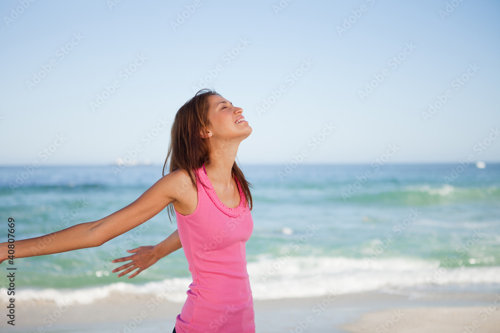 Young woman standing upright while sunbathing on the beach Young woman standing upright while sunbathing on the beach