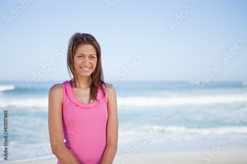 Young smiling woman standing upright in front of the sea © WavebreakmediaMicro