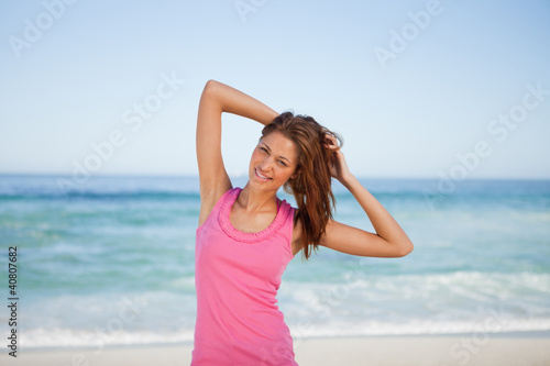 Young woman placing her hands behind her head on the beach