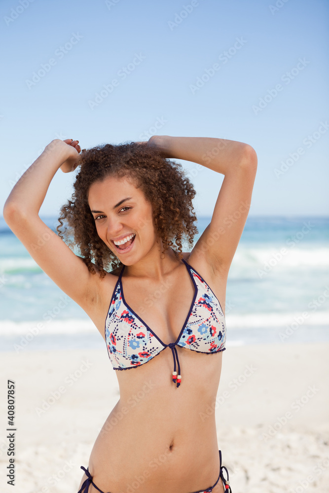 Smiling young woman raising her arms above the head in front of Smiling young woman raising her arms above the head in front of