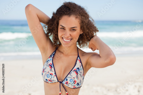 Young smiling woman placing her hands behind her head