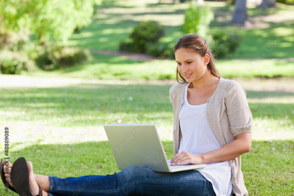 Woman sitting on the lawn with her laptop Woman sitting on the lawn with her laptop