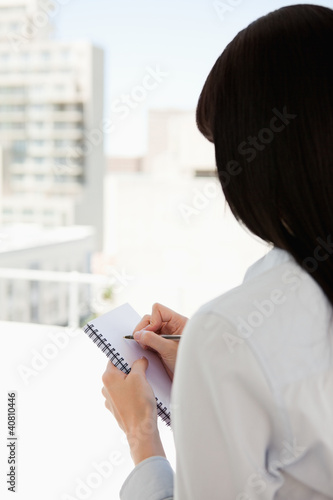 A woman begins to write down on her notepad