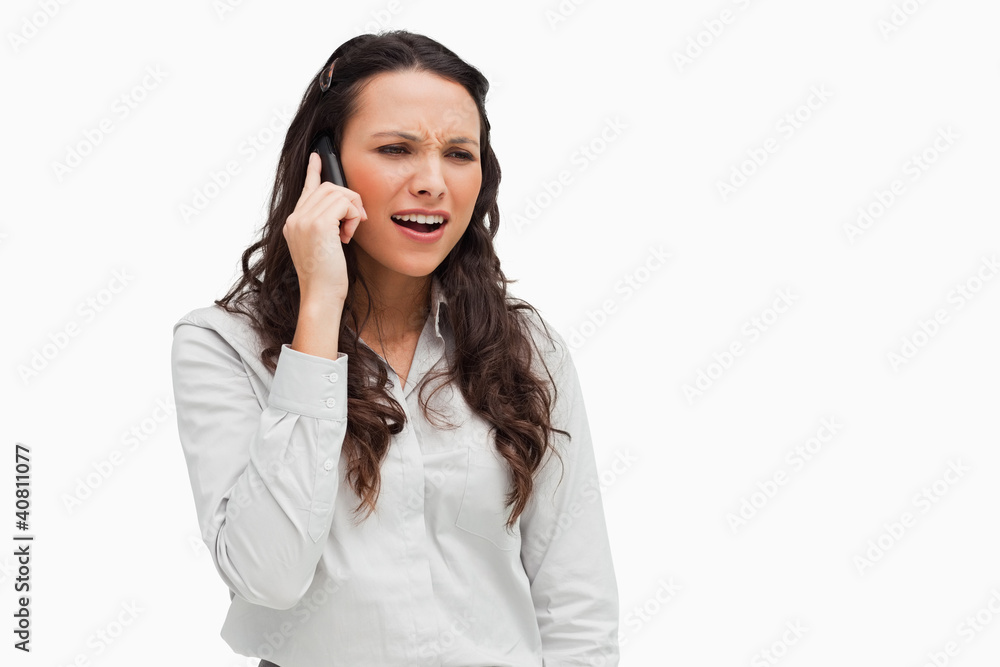 Close-up of a brunette grimacing on the phone Close-up of a brunette grimacing on the phone