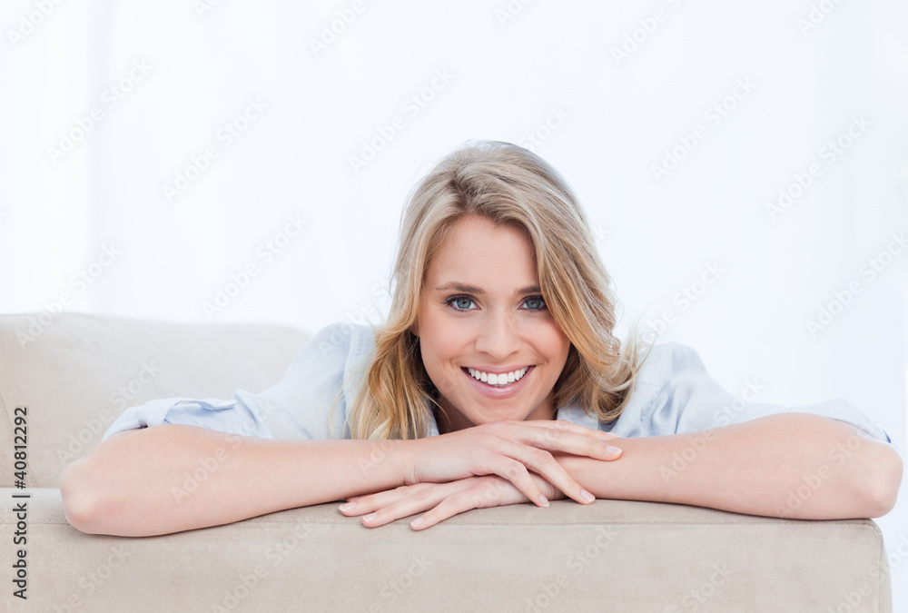 A smiling woman looking at the camera is resting her chin on her A smiling woman looking at the camera is resting her chin on her