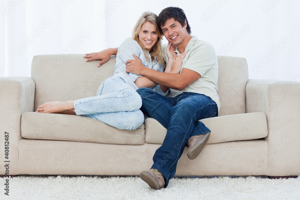 A couple sitting on a couch embracing each other A couple sitting on a couch embracing each other