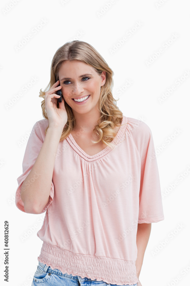 Smiling young woman is talking on her mobile phone Smiling young woman is talking on her mobile phone
