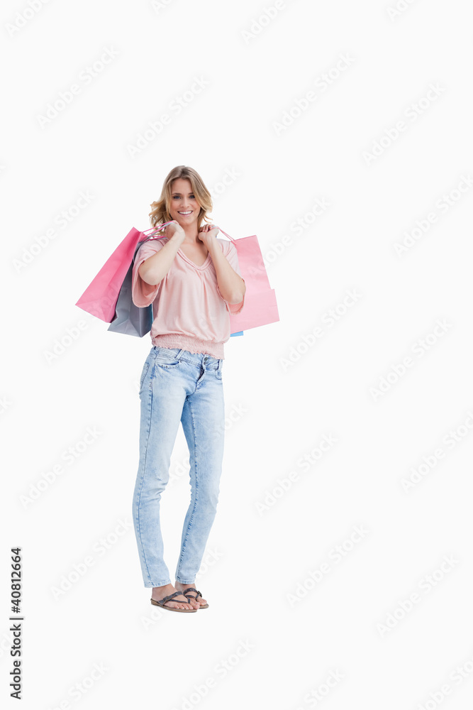 A woman is carrying shopping bags over her shoulder