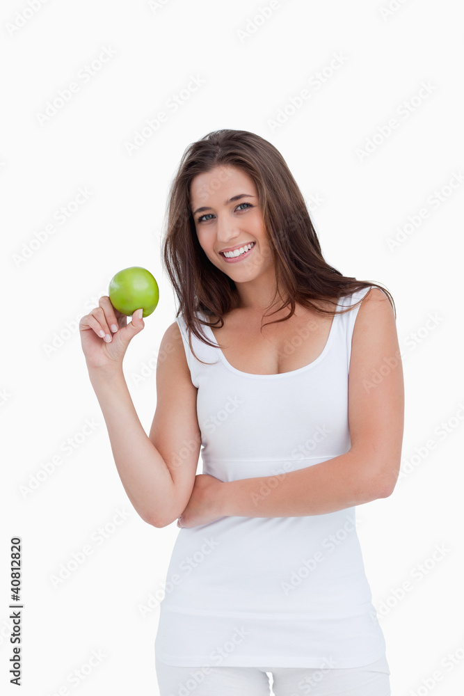 Smiling brunette woman holding a green apple Smiling brunette woman holding a green apple