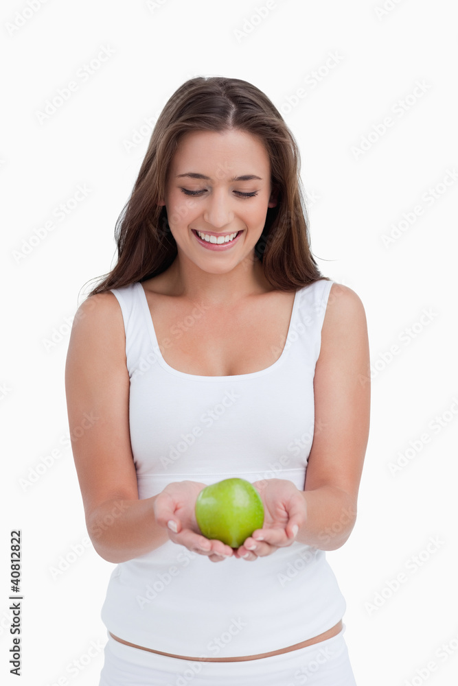 Smiling brunette woman holding a beautiful green apple Smiling brunette woman holding a beautiful green apple