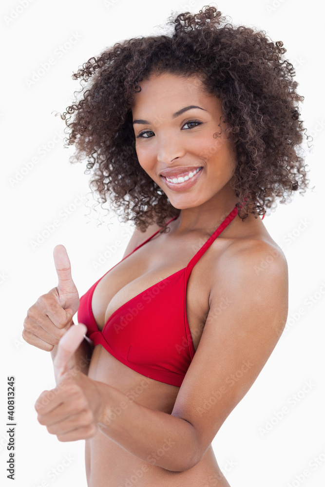 Attractive woman looking at the camera while placing her thumbs Attractive woman looking at the camera while placing her thumbs