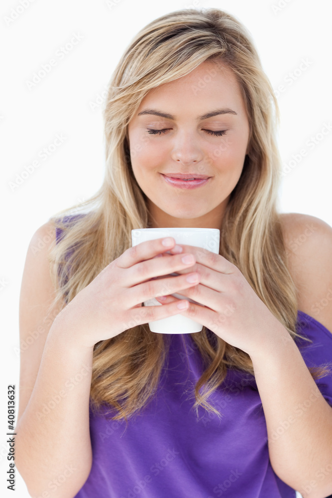 Young woman smelling her cup of coffee Young woman smelling her cup of coffee