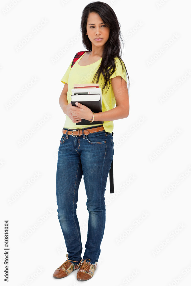 Pretty Latin student with backpack holding textbooks Pretty Latin student with backpack holding textbooks