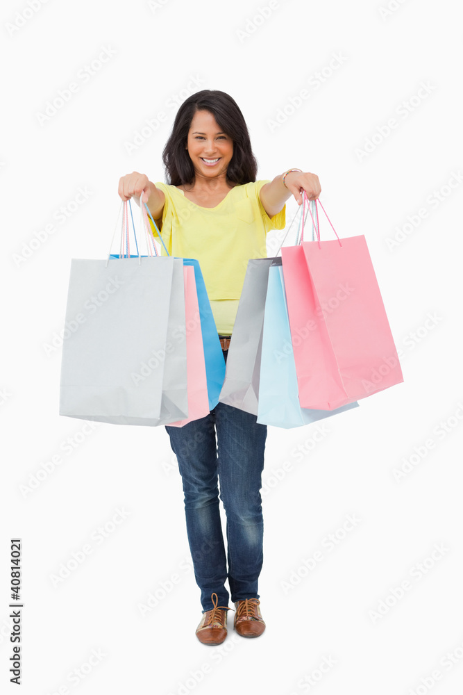 Beautiful Latin student showing her shopping bags