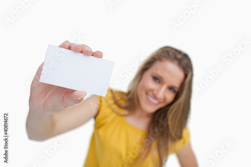 Close-up of a blond woman showing a white card