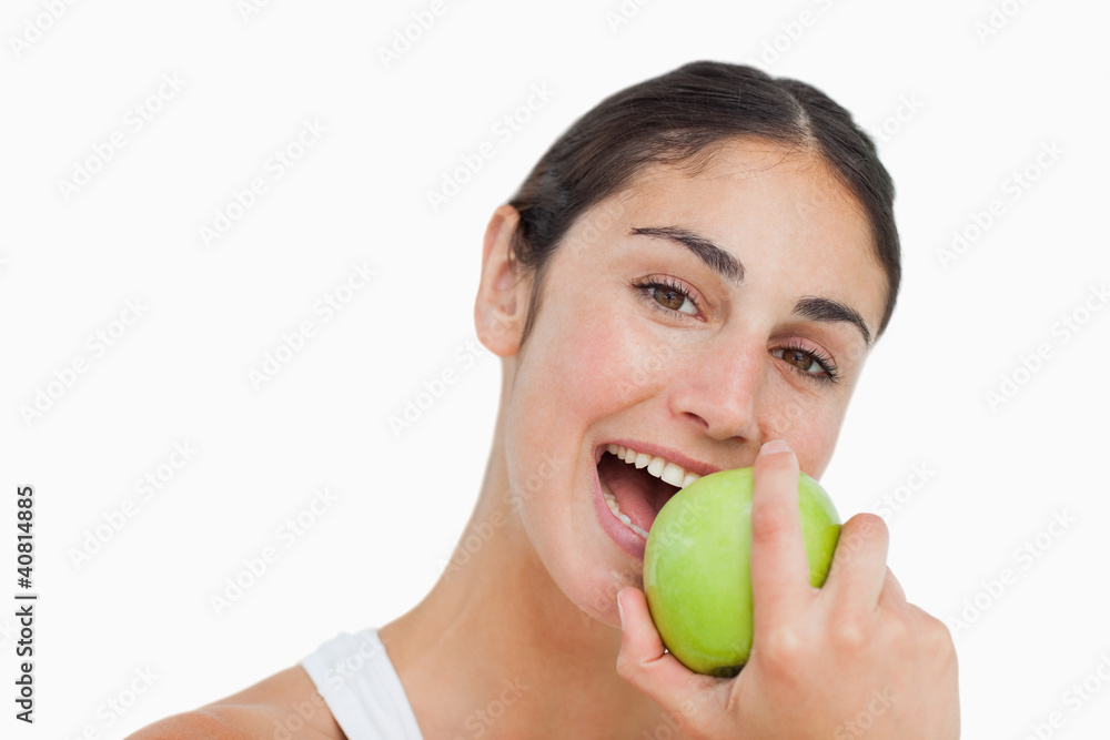 Close-up a brunette eating a green apple Close-up a brunette eating a green apple