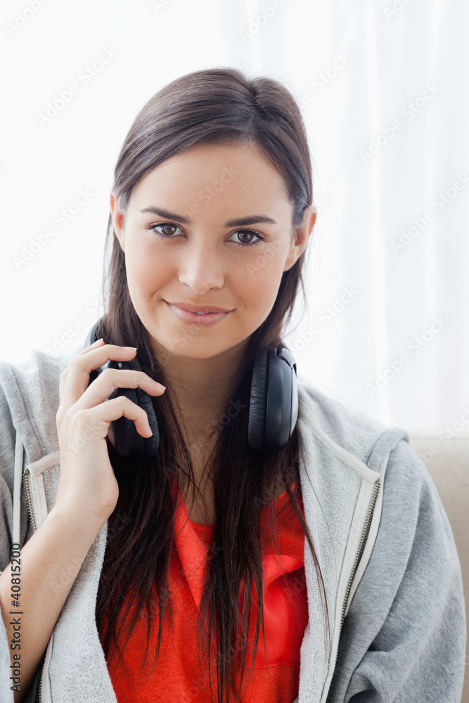 A slightly smiling woman with headphones as she looks into the c A slightly smiling woman with headphones as she looks into the c