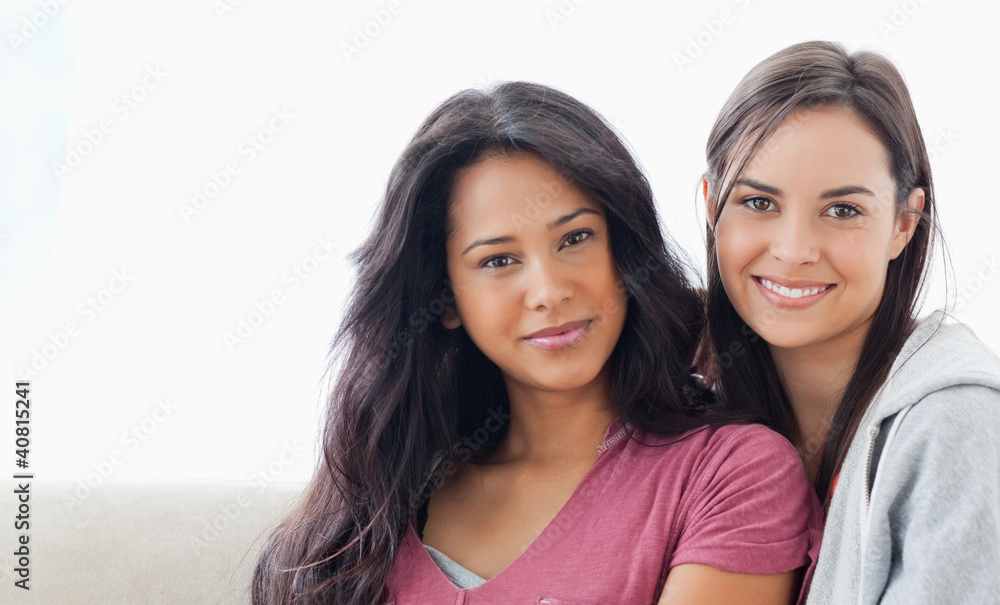 Head and shoulder shot of two women lying against each other whi Head and shoulder shot of two women lying against each other whi