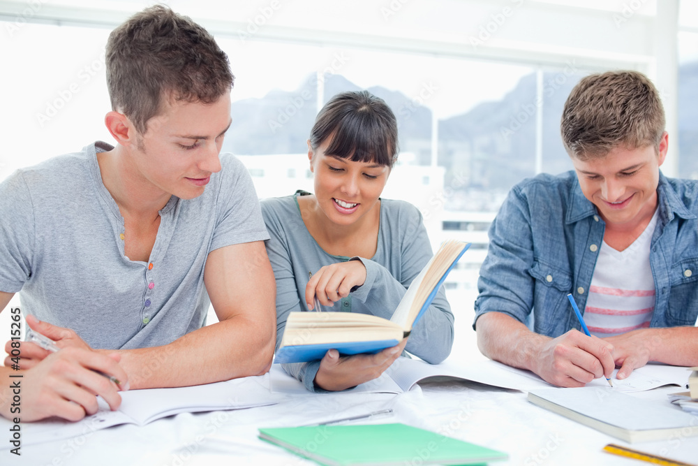 A group of students sitting together as they all study A group of students sitting together as they all study