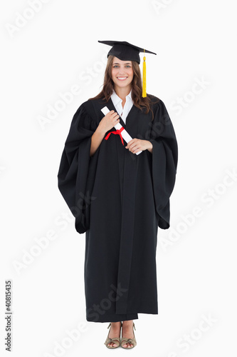 Full length shot of a graduate holding a degree and looking at t