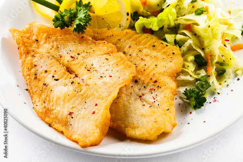 Fish dish - fried fish fillets and vegetable salad