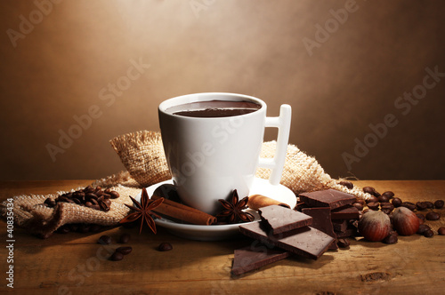 cup of hot chocolate, cinnamon sticks, nuts and chocolate