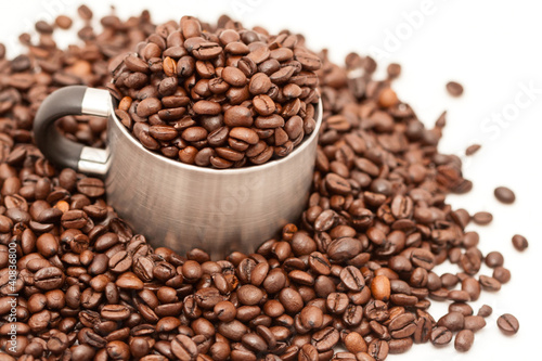 metal mug filled by coffee beans