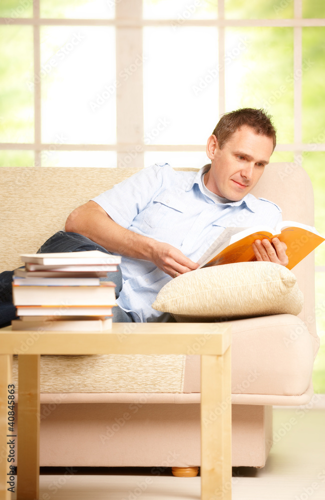 Man reading book in room