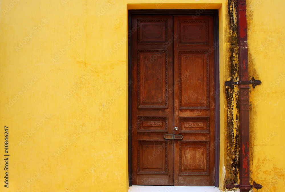 wooden door on yellow wall in old palace, Thailand wooden door on yellow wall in old palace, Thailand