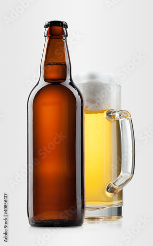 Beer into glass and bottle on a gray