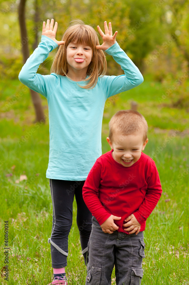 Brother and sister posing outside on beautiful spring day Brother and sister posing outside on beautiful spring day