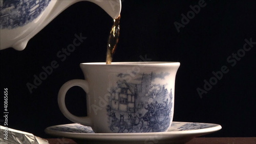 Tea is poured into a cup