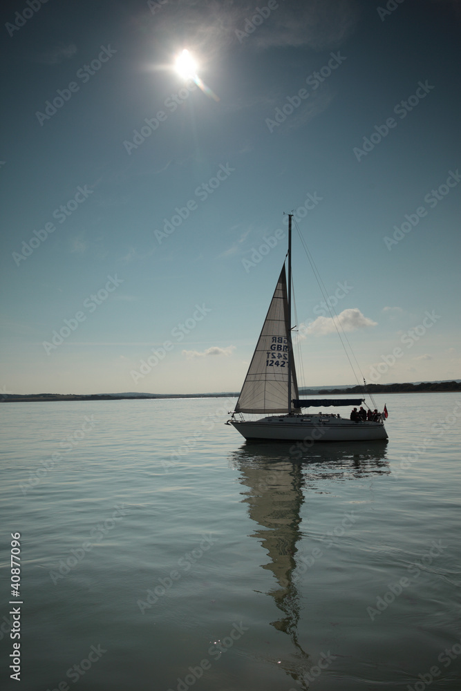 yacht against a blue sky on a still sea
